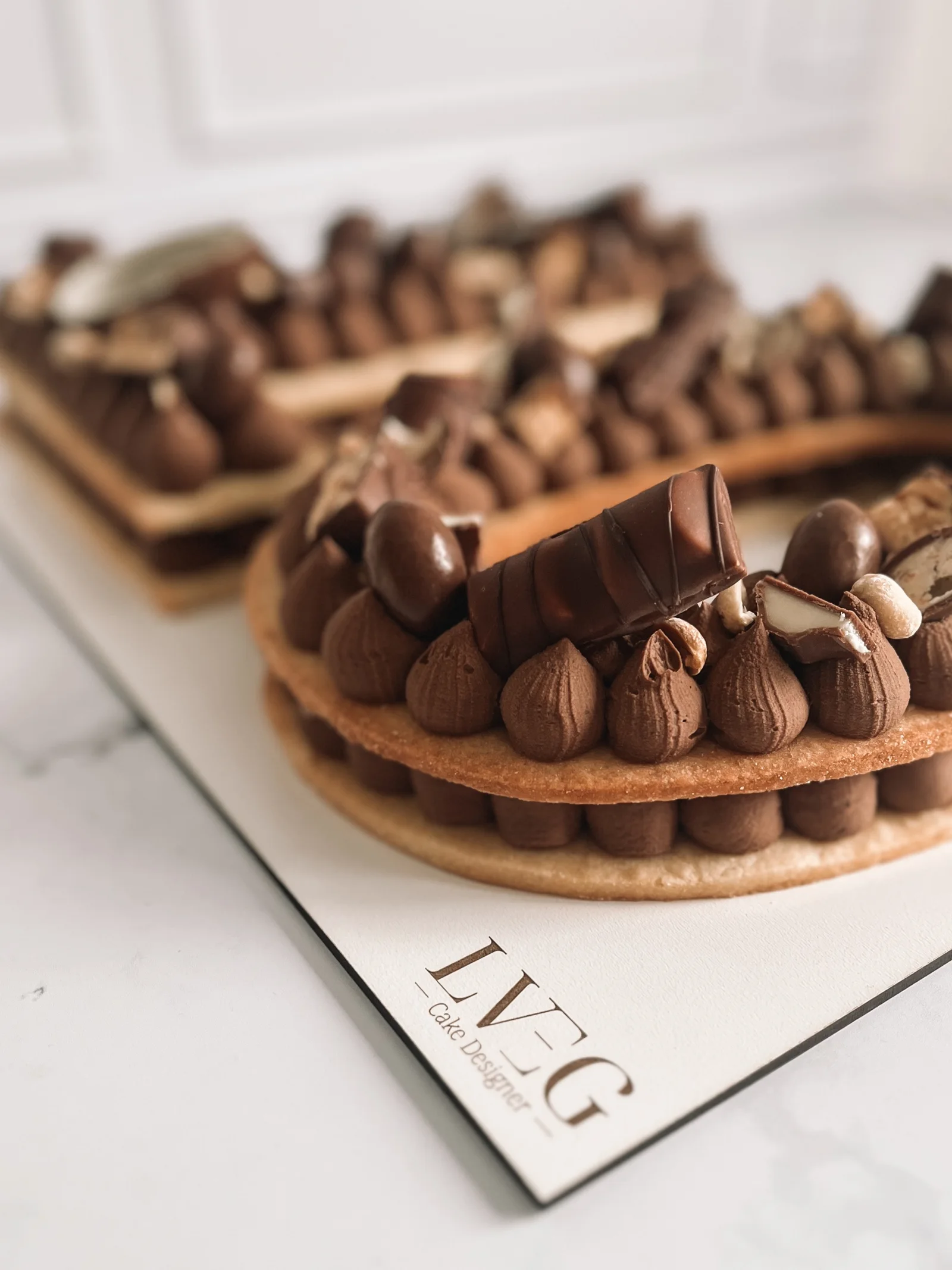 Number cake au chocolat posé sur un socle gravé du logo LVEG Cake Designer