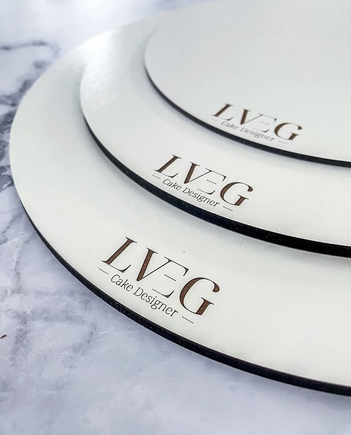 Gros plan sur le logo LVEG Cake Designer gravé dans les socles