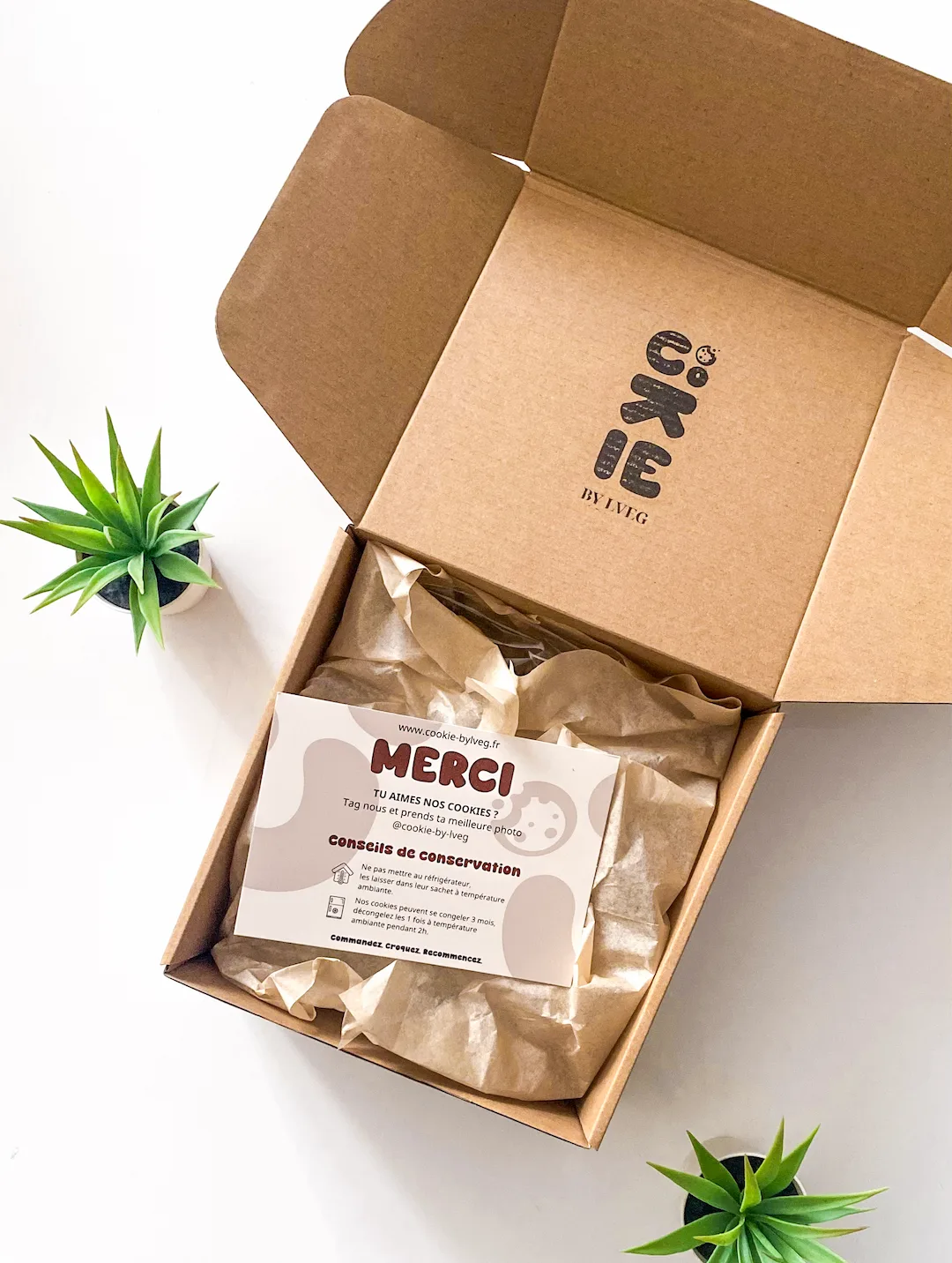 Boîte de livraison Cookie By LVEG ouverte, avec sa carte de remerciement
